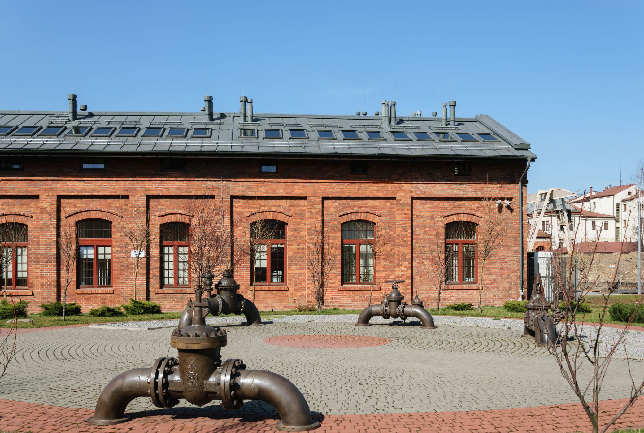 Zrewitalizowany budynek Gazowni w Krakowie z dachem RHEINZINK, otoczony zielenią, prezentujący zrównoważone podejście do architektury i długowieczność materiałów. Zrewitalizowany budynek Gazowni w Krakowie z dachem RHEINZINK, otoczony zielenią, prezentujący zrównoważone podejście do architektury i długowieczność materiałów.